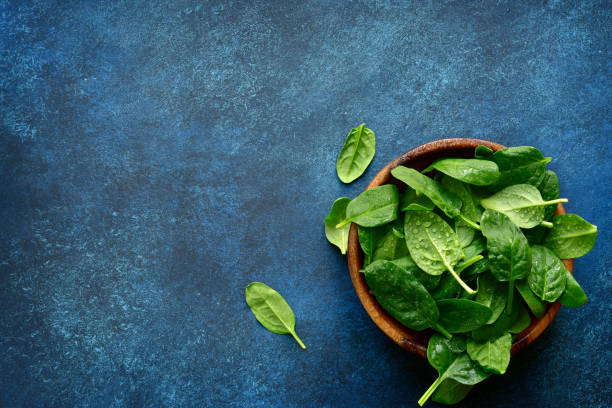 istock Fresh organic spinach leaves in a wooden bowl 1132622606