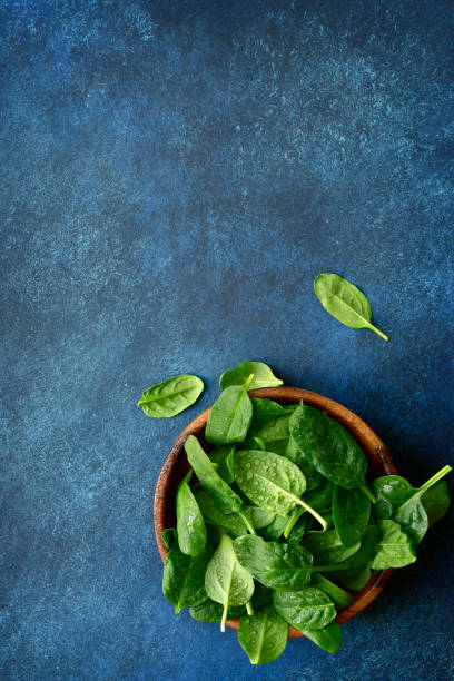 istock Fresh organic spinach leaves in a wooden bowl 1132622621