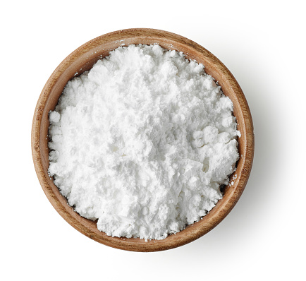 wooden bowl of powdered sugar isolated on white background, top view