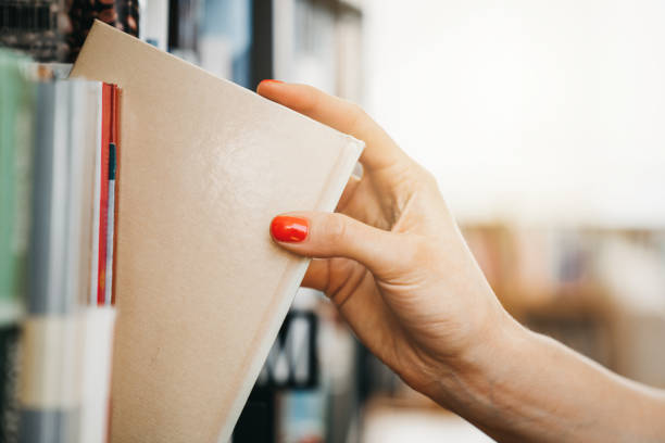 istock A girl taking a book from a shelf in a library 1132626667