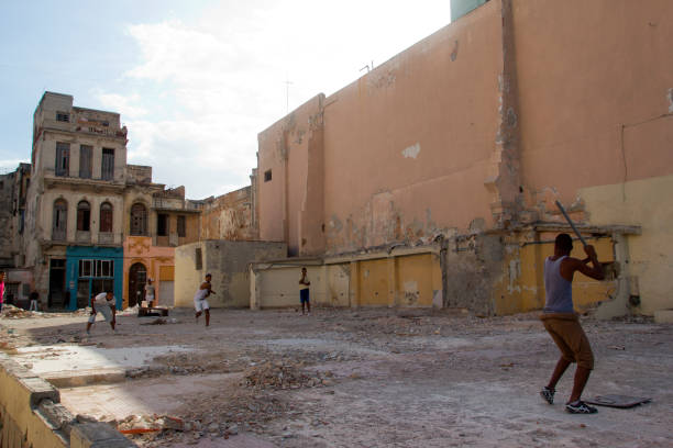 Young people playing baseball on a field along the Malecon n Havana. Baseball is one of Cuba's most famous national sports