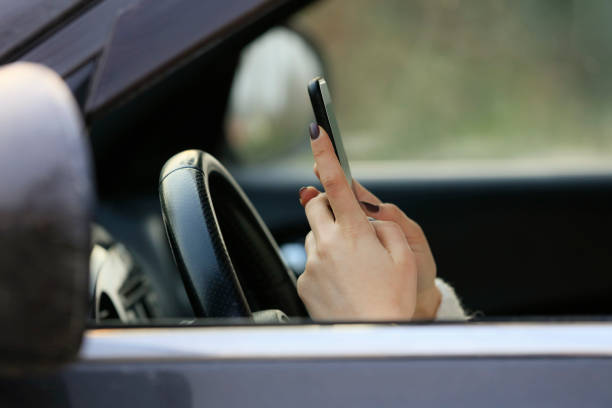 mujer conduciendo coche distraído por su teléfono móvil - driving text messaging accident car fotografías e imágenes de stock