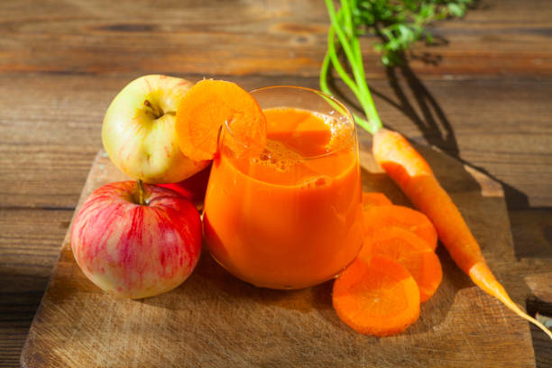 Carrot juice in glass on wooden table