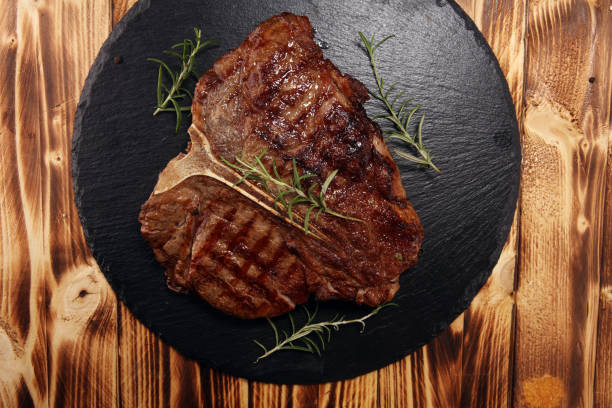 istock Grilled T-bone steak on stone cutting board. 1132643839