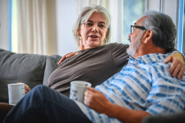 istock Smiling senior couple holding coffee cups on sofa 1132644967