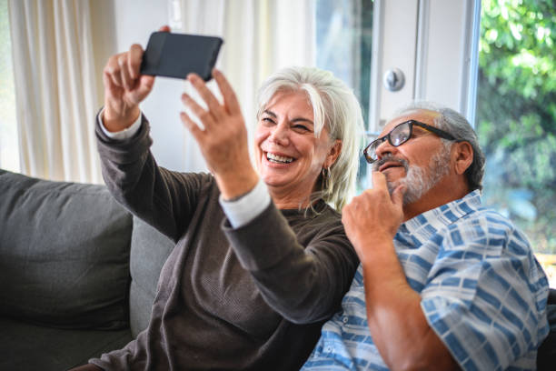 istock Senior couple taking selfie on sofa at home 1132644971
