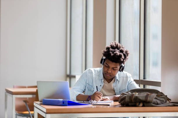 istock Male high school student studies in campus library 1132647177