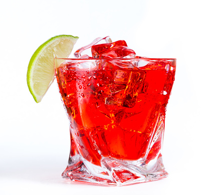 close up of a refreshing classic cocktail with vodka and cranberry juice served on the rocks with a lime wedge garnish isolated on a white background