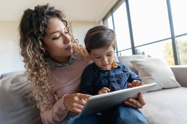 istock Happy mother and son watching videos on a tablet computer at home 1132647566