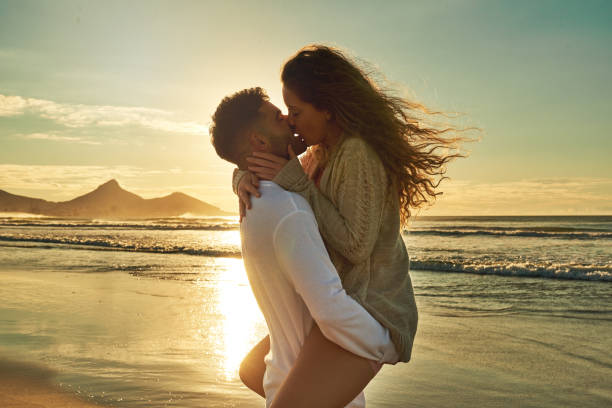 Cropped shot of an affectionate young couple sharing an intimate moment on the beach