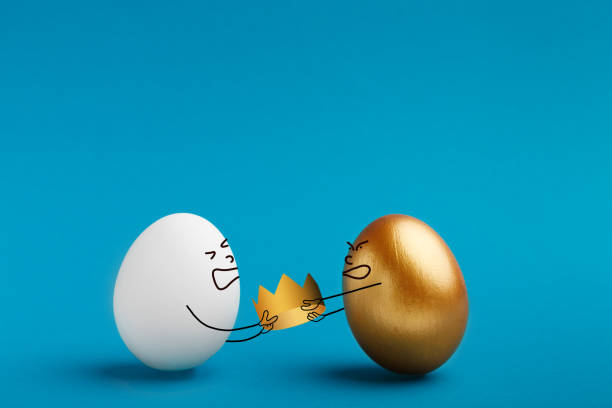 istock Leadership tussle among two eggs, white and golden 1132648394