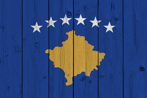 Kosovo flag painted on old wood plank. Patriotic background. National flag of Kosovo