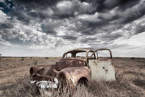 An old and abandoned vintage car left to rust away in the outback.