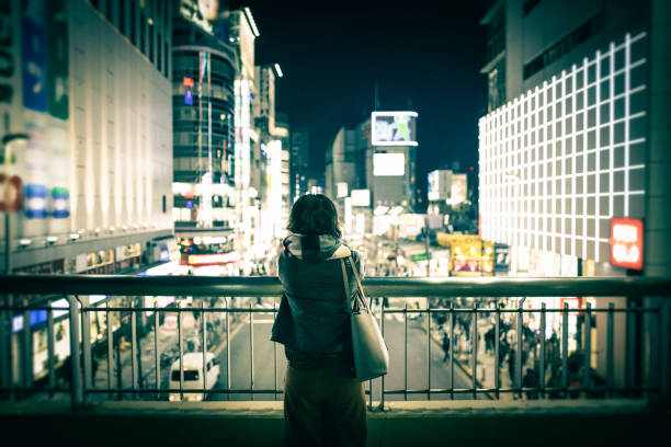都会の夜景を眺めている若い女性 - 日本人　女性　20代　仕事 ストックフォトと画像
