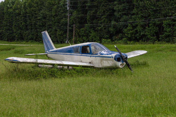 istock Abandoned blue and white single prop plane in green grass field 1132654901