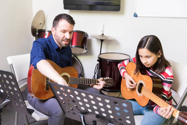 etudiant étudiant la musique comme un hobby - guitar child music learning photos et images de collection