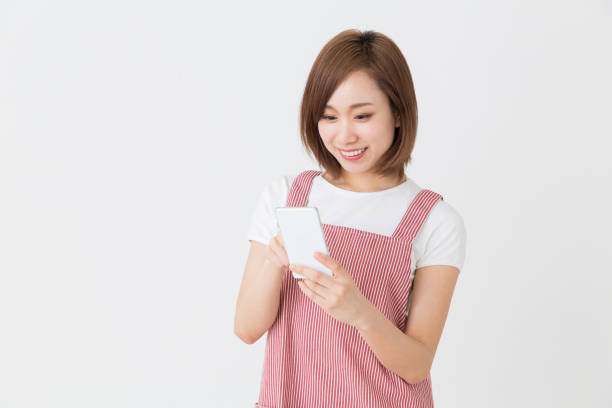 young attractive asian woman who cooks while watching a smart phone