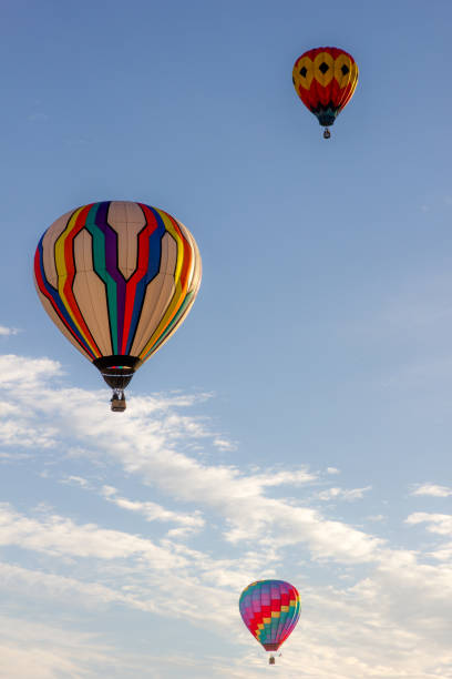 les ballons d'air chaud de couleur vive flottent dans le ciel bleu clair sur un matin d'automne croustillant. - balloon moving up child flying photos et images de collection