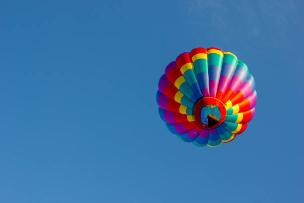 les ballons d'air chaud de couleur vive flottent dans le ciel bleu clair sur un matin d'automne croustillant. - balloon moving up child flying photos et images de collection