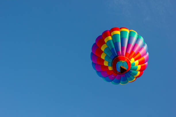 le mongolfiere dai colori vivaci galleggiano nel cielo cristallino in una frizzante mattina d'autunno. - balloon moving up child flying foto e immagini stock