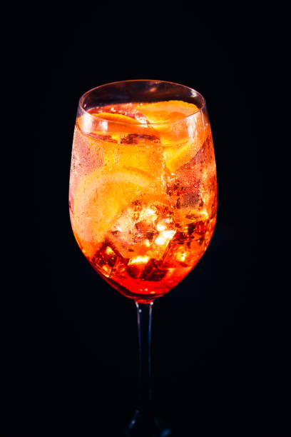 istock Stylish alcoholic Spritz cocktail with orange slice on black background. 1132668579