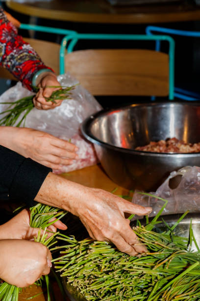 In Chinese families, the family prepares dumplings together, and mixes meat, onions, ginger, garlic, leeks, cabbage, and eggs to make dumplings and make Chinese dumplings. In Chinese families, the family prepares dumplings together, and mixes meat, onions, ginger, garlic, leeks, cabbage, and eggs to make dumplings and make Chinese dumplings. 塞滿的 stock pictures, royalty-free photos & images