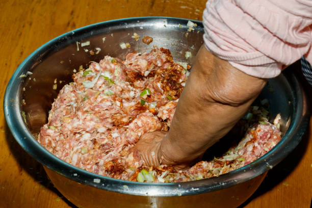 In Chinese families, the family prepares dumplings together, and mixes meat, onions, ginger, garlic, leeks, cabbage, and eggs to make dumplings and make Chinese dumplings. In Chinese families, the family prepares dumplings together, and mixes meat, onions, ginger, garlic, leeks, cabbage, and eggs to make dumplings and make Chinese dumplings. 塞滿的 stock pictures, royalty-free photos & images