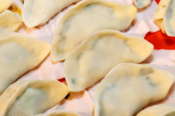 In Chinese families, the family prepares dumplings together, and mixes meat, onions, ginger, garlic, leeks, cabbage, and eggs to make dumplings and make Chinese dumplings. In Chinese families, the family prepares dumplings together, and mixes meat, onions, ginger, garlic, leeks, cabbage, and eggs to make dumplings and make Chinese dumplings. 塞滿的 stock pictures, royalty-free photos & images