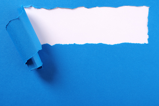 Torn blue paper strip curled edge background frame
