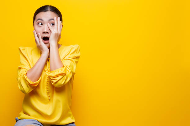 istock Woman feel scared standing isolated over yellow background 1132674561