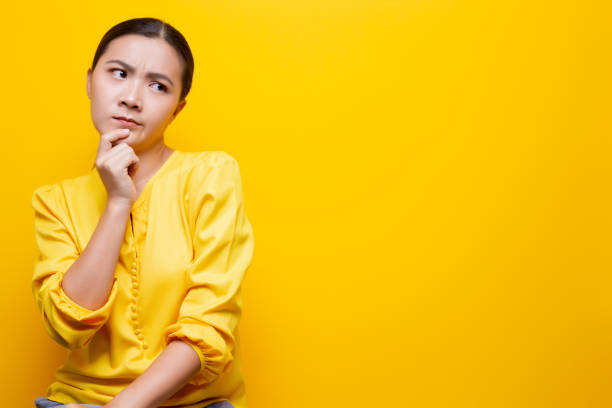 istock Woman feel confused isolated over yellow background 1132675285