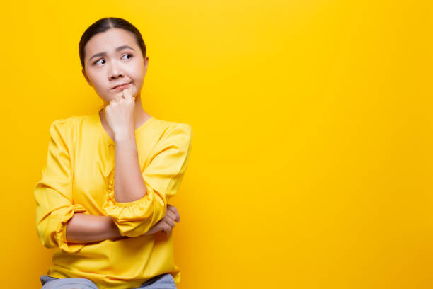 istock Woman feel confused isolated over yellow background 1132675288