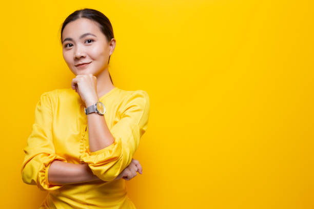 istock Happy woman thinking and standing isolated over yellow background 1132675295
