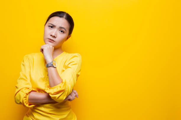 istock Woman feel confused isolated over yellow background 1132675341