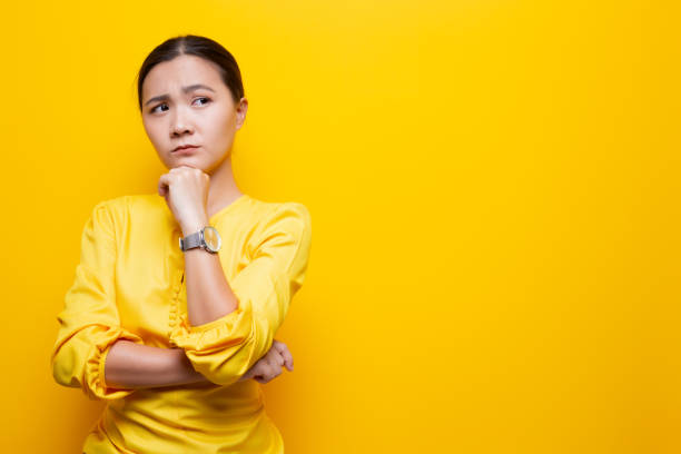 istock Woman feel confused isolated over yellow background 1132675352