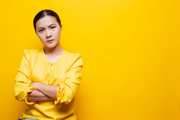 istock Angry woman standing isolated over yellow background 1132675387