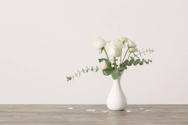 istock eucalyptus twigs and roses  in  vase on white background 1132680089