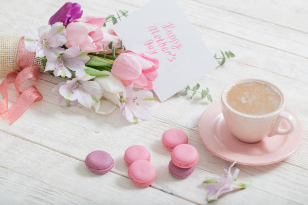 istock Tulips and cup of coffee with dessert on white background. Conce 1132680167