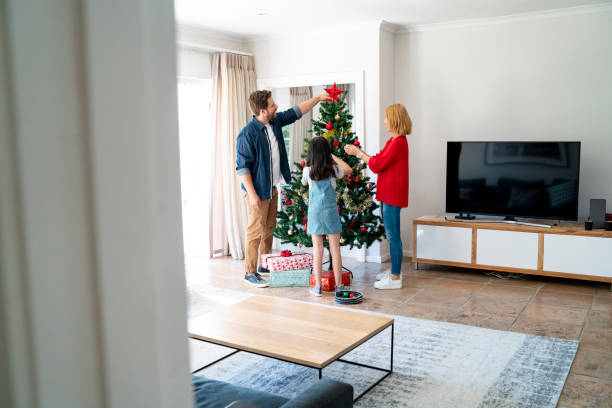 istock Parents and daughter decorating Christmas tree 1132681631