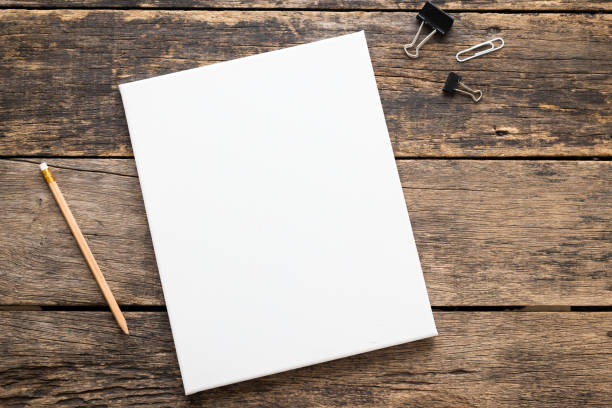 istock Empty white canvas frame with pencil on a wooden background. 1132681687