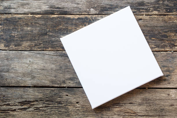 istock Empty white canvas frame with pencil on a wooden background. 1132681740