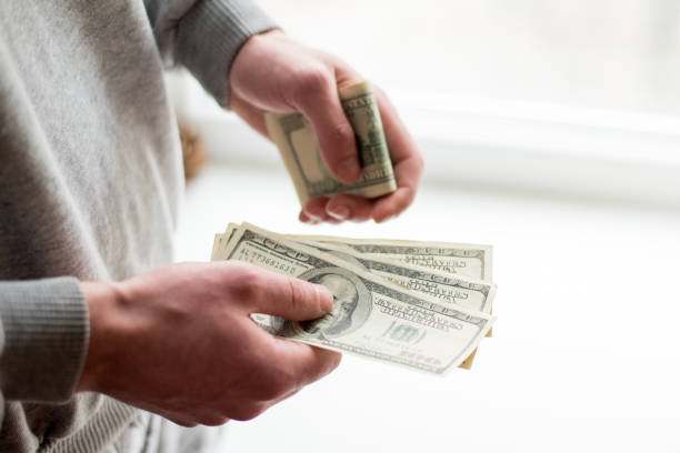 istock Man's hands with dollars on white background. man gives a bribe . corruption background 1132682364
