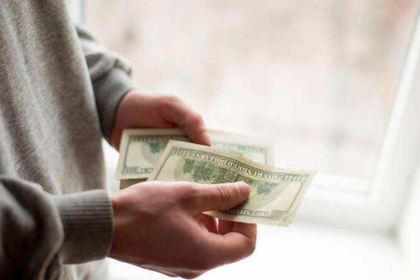 istock Man's hands with dollars on white background. man gives a bribe . corruption background 1132682417