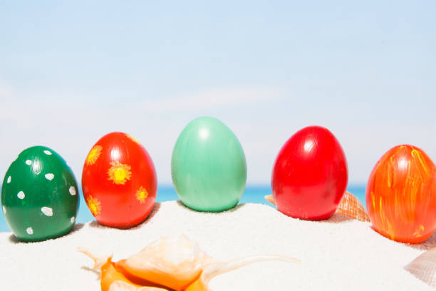 Easter on tropical beach background. Eggs on the white sand. Vacation and travel concept in spring