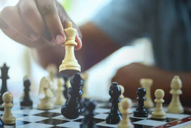 Hand of businessman playing chess game,competition success play,management or leadership concept.