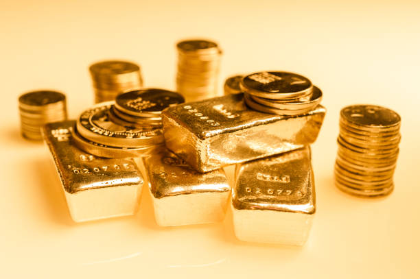 lingotti d'oro e pila di monete d'oro. contesto per il concetto di banca finanziaria. commercio di metalli preziosi. - gold ingot coin bullion foto e immagini stock