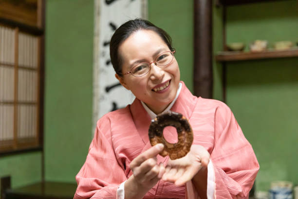 istock Japanese woman eating donut 1132698294