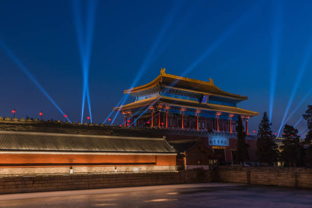 Vast Tiananmen Square in Beijing features prominent red flags fluttering against a bright blue sky, echoing history.