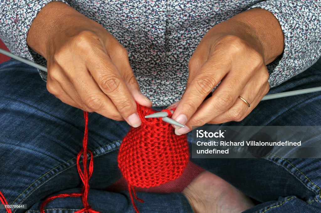 Knit with red wool close-up of a non-recognizable woman knitting Ball Of Wool Stock Photo