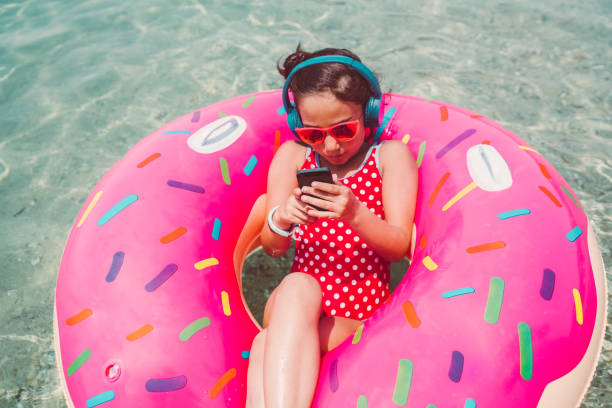 istock Kid floating on water in donut life belt 1132705672